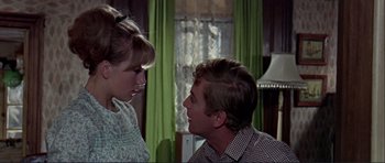 Movie still from “Alfie” (1966), directed by Lewis Gilbert – A man and a woman looking at one another in front of a window; Medium shot, Over the shoulder angle