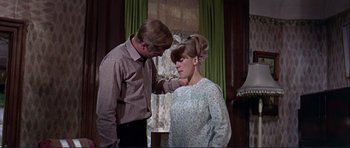 Movie still from “Alfie” (1966), directed by Lewis Gilbert – A man and a woman standing next to each other in front of a window; Medium shot, Low angle