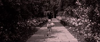 Movie still from “Alfie” (1966), directed by Lewis Gilbert – A young boy running down a path holding a ball; Wide shot, High angle