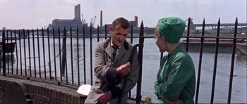 Movie still from “Alfie” (1966), directed by Lewis Gilbert – A man and a woman standing next to a body of water; Medium shot, Over the shoulder angle