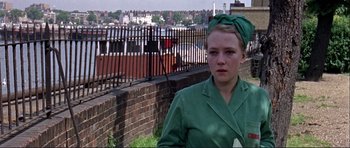Movie still from “Alfie” (1966), directed by Lewis Gilbert – A woman in a green dress standing in front of a fence; Close Up shot, High angle