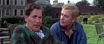 Movie still from “Alfie” (1966), directed by Lewis Gilbert – Two older men standing next to each other; Medium shot, Over the shoulder angle