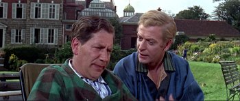 Movie still from “Alfie” (1966), directed by Lewis Gilbert – Two older men are talking to each other outside; Medium shot, Over the shoulder angle