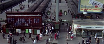 Movie still from “Alfie” (1966), directed by Lewis Gilbert – A group of people walking on a train platform near train tracks; Extreme Wide shot, High angle