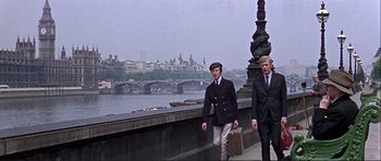 Movie still from “Alfie” (1966), directed by Lewis Gilbert – Two men walking on a bridge near a body of water; Wide shot, Low angle