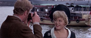 Movie still from “Alfie” (1966), directed by Lewis Gilbert – A man taking a picture of a woman in a black hat; Close Up shot, Over the shoulder angle
