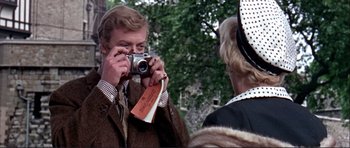 Movie still from “Alfie” (1966), directed by Lewis Gilbert – A man taking a picture of a woman holding a camera; Close Up shot, Over the shoulder angle