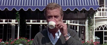 Movie still from “Alfie” (1966), directed by Lewis Gilbert – A man drinking a cup of coffee from a mug; Close Up shot, Low angle
