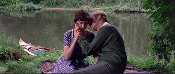 Movie still from “Alfie” (1966), directed by Lewis Gilbert – A man and a woman sitting next to a body of water; Medium shot, High angle