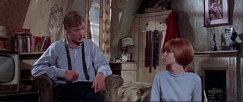 Movie still from “Alfie” (1966), directed by Lewis Gilbert – A man and a woman sitting in a living room; Medium shot, Over the shoulder angle