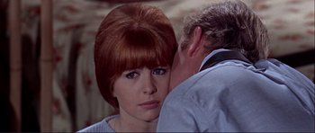 Movie still from “Alfie” (1966), directed by Lewis Gilbert – A woman with red hair is holding a man's face; Close Up shot, High angle
