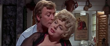 Movie still from “Alfie” (1966), directed by Lewis Gilbert – An older man kissing a younger woman on the cheek; Close Up shot, Over the shoulder angle