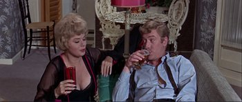 Movie still from “Alfie” (1966), directed by Lewis Gilbert – A man and a woman sitting down drinking beer; Medium shot, Over the shoulder angle