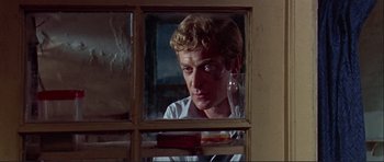 Movie still from “Alfie” (1966), directed by Lewis Gilbert – A man looking out of a window in a room; Close Up shot, Low angle