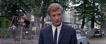 Movie still from “Alfie” (1966), directed by Lewis Gilbert – A person wearing a suit and tie; Close Up shot, Low angle