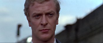 Movie still from “Alfie” (1966), directed by Lewis Gilbert – A person wearing a suit and tie; Close Up shot, Low angle