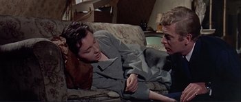 Movie still from “Alfie” (1966), directed by Lewis Gilbert – A man and a woman laying on a couch; Medium shot, High angle