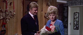 Movie still from “Alfie” (1966), directed by Lewis Gilbert – A man and a woman holding a bouquet of flowers; Medium shot, High angle