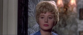 Movie still from “Alfie” (1966), directed by Lewis Gilbert – An older woman with blonde hair and a blue shirt; Close Up shot, Over the shoulder angle