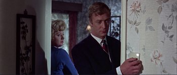 Movie still from “Alfie” (1966), directed by Lewis Gilbert – A man and a woman standing next to each other in a room; Medium shot, Low angle