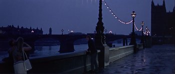 Movie still from “Alfie” (1966), directed by Lewis Gilbert – A man leaning on a wall near a body of water at night; Wide shot, High angle