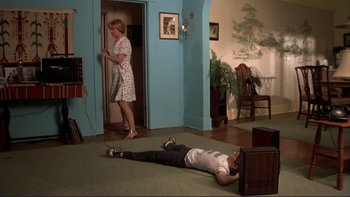 Movie still from “Alice Doesn't Live Here Anymore” (1974), directed by Martin Scorsese – A man laying on the ground next to a woman in a living room; Wide shot, High angle