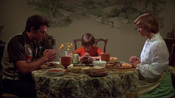 Movie still from “Alice Doesn't Live Here Anymore” (1974), directed by Martin Scorsese – A group of people sitting at a table with plates of food on it; Medium shot, High angle