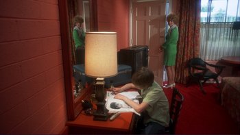 Movie still from “Alice Doesn't Live Here Anymore” (1974), directed by Martin Scorsese – A woman standing in front of a mirror looking in a mirror; Medium shot, High angle