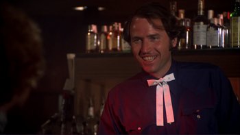 Movie still from “Alice Doesn't Live Here Anymore” (1974), directed by Martin Scorsese – A man in a red shirt and a white bow tie; Close Up shot, Over the shoulder angle