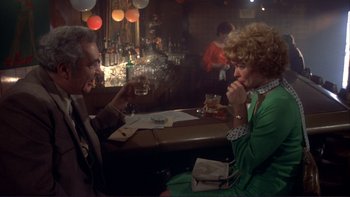 Movie still from “Alice Doesn't Live Here Anymore” (1974), directed by Martin Scorsese – A man and a woman sitting at a table with drinks in front of them; Medium shot, High angle