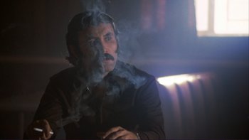 Movie still from “Alice Doesn't Live Here Anymore” (1974), directed by Martin Scorsese – A man smoking a cigarette in a dark room; Close Up shot, Low angle