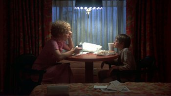 Movie still from “Alice Doesn't Live Here Anymore” (1974), directed by Martin Scorsese – Two people sitting at a table eating food; Medium shot, High angle