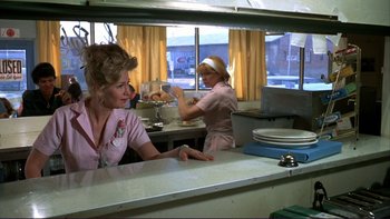 Movie still from “Alice Doesn't Live Here Anymore” (1974), directed by Martin Scorsese – Two women in a kitchen preparing a meal; Medium shot, Over the shoulder angle