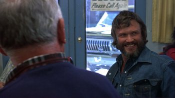 Movie still from “Alice Doesn't Live Here Anymore” (1974), directed by Martin Scorsese – A man with a beard is talking to another man in front of a building; Close Up shot, Over the shoulder angle