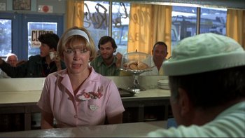 Movie still from “Alice Doesn't Live Here Anymore” (1974), directed by Martin Scorsese – A group of people sitting at a table in front of a window; Medium shot, Over the shoulder angle