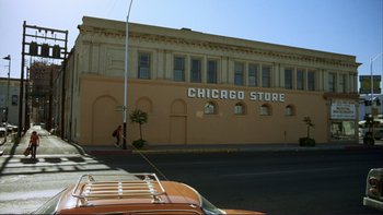 Movie still from “Alice Doesn't Live Here Anymore” (1974), directed by Martin Scorsese – A building that has a sign on the side of the building; Extreme Wide shot, Low angle