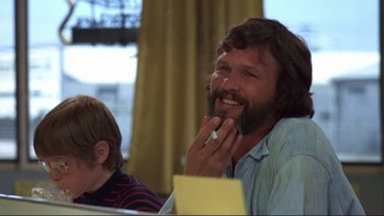 Movie still from “Alice Doesn't Live Here Anymore” (1974), directed by Martin Scorsese – A man sitting in front of another man with a beard; Close Up shot, Low angle