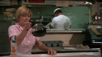 Movie still from “Alice Doesn't Live Here Anymore” (1974), directed by Martin Scorsese – A woman holding a jar in a restaurant kitchen; Medium shot, Low angle