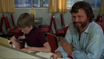Movie still from “Alice Doesn't Live Here Anymore” (1974), directed by Martin Scorsese – A man and a boy sitting at a table in a restaurant; Medium shot, Over the shoulder angle