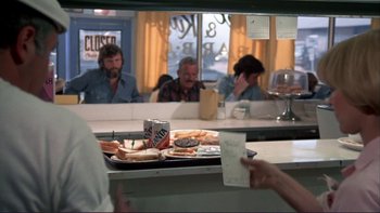 Movie still from “Alice Doesn't Live Here Anymore” (1974), directed by Martin Scorsese – A group of people sitting at a table in a restaurant; Medium shot, Over the shoulder angle