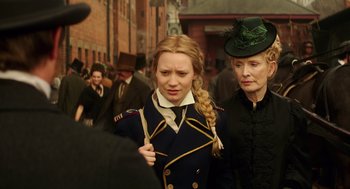 Movie still from “Alice Through the Looking Glass” (2016), directed by James Bobin – A woman in a military uniform and a woman in a green hat; Close Up shot, Over the shoulder angle