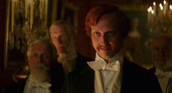 Movie still from “Alice Through the Looking Glass” (2016), directed by James Bobin – A person wearing a suit and bow tie; Close Up shot, Low angle