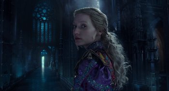Movie still from “Alice Through the Looking Glass” (2016), directed by James Bobin – A woman with long blonde hair standing in a dark room; Close Up shot, Over the shoulder angle
