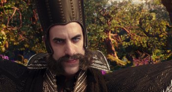Movie still from “Alice Through the Looking Glass” (2016), directed by James Bobin – A person with a beard wearing a hat; Close Up shot, Over the shoulder angle