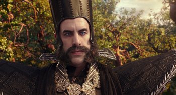 Movie still from “Alice Through the Looking Glass” (2016), directed by James Bobin – A person with a beard wearing a costume; Close Up shot, Over the shoulder angle
