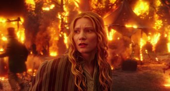 Movie still from “Alice Through the Looking Glass” (2016), directed by James Bobin – A woman standing in front of a burning building; Close Up shot, Low angle