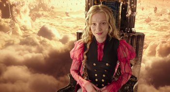 Movie still from “Alice Through the Looking Glass” (2016), directed by James Bobin – A young girl sitting in a chair in front of a sky background; Medium shot, Low angle