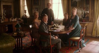 Movie still from “Alice Through the Looking Glass” (2016), directed by James Bobin – A group of people sitting around a table in a room; Wide shot, High angle