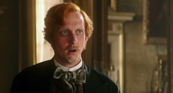 Movie still from “Alice Through the Looking Glass” (2016), directed by James Bobin – A person wearing a suit and a bow tie; Close Up shot, Low angle