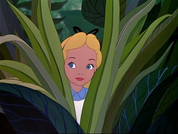 Movie still from “Alice in Wonderland” (1951), directed by Wilfred Jackson – A girl with blonde hair is hiding behind a plant; Medium shot, High angle